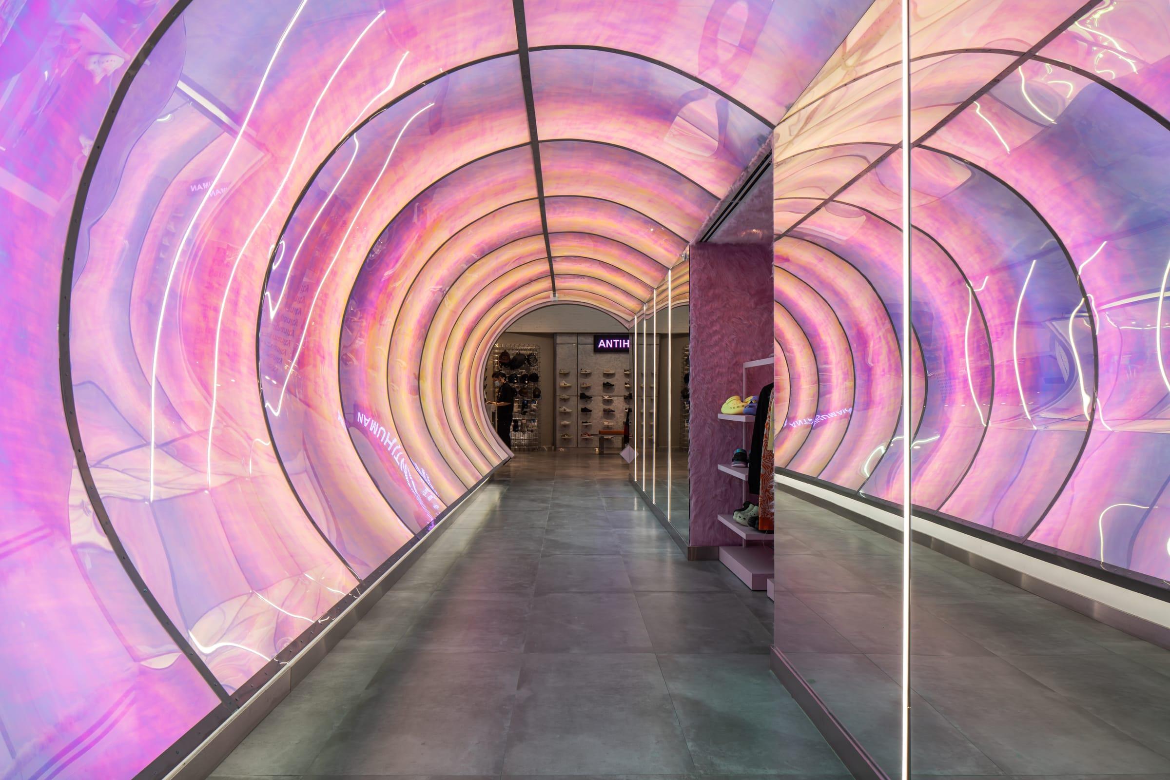 A tunnel of pink light at the entrance of an Antihuman store.