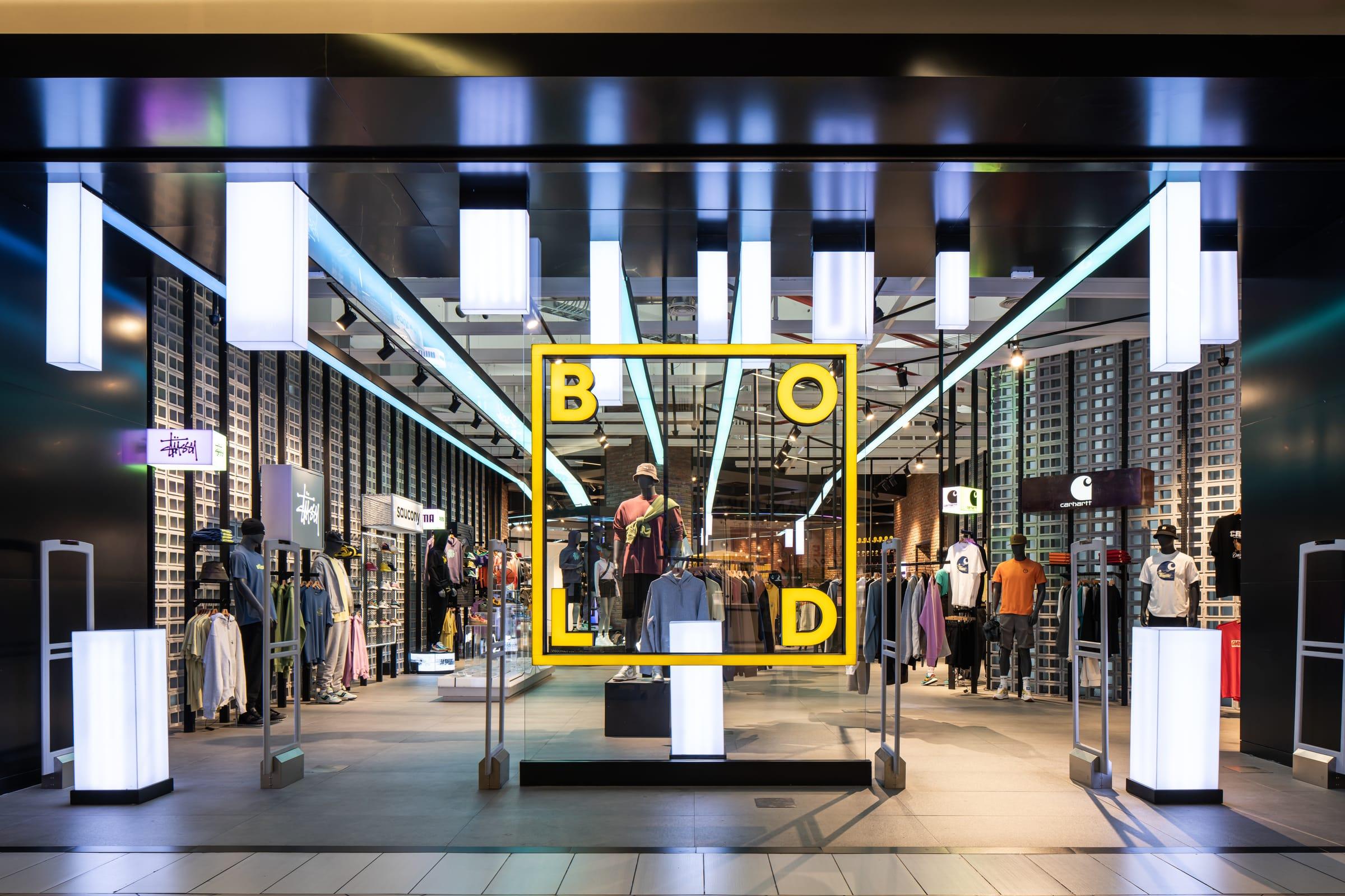 The entrance of a Bold store: the yellow logo frames the window and the lit aisle.